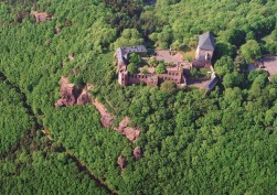 Luftaufnahme der Burg Nideggen. Diese steht auf einem Felsen und ist von Wald umgeben.